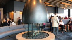 a fireplace in a room with people around it