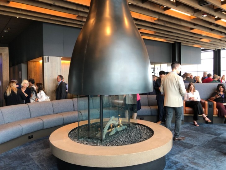 a fireplace in a room with people around it