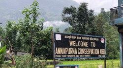 a sign in front of a mountain