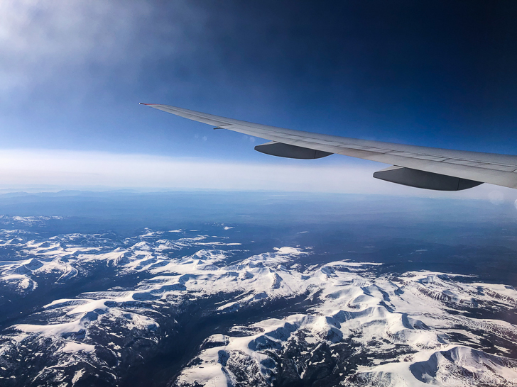 an airplane wing and snowy mountains