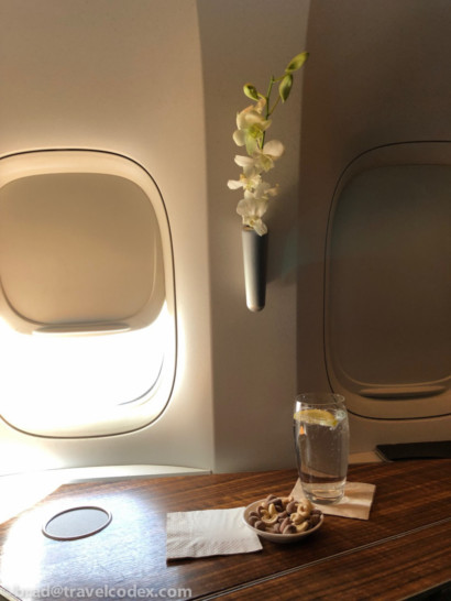 a table with a glass of water and a flower vase on the side of it