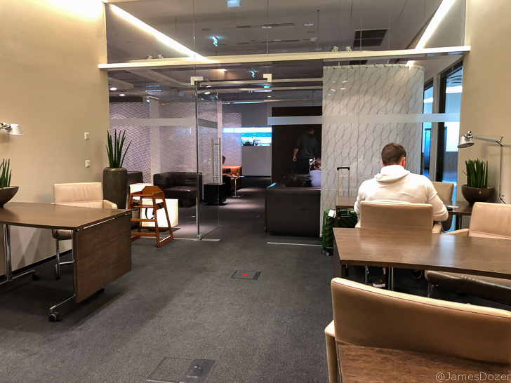 a man sitting at a table in a room with glass walls
