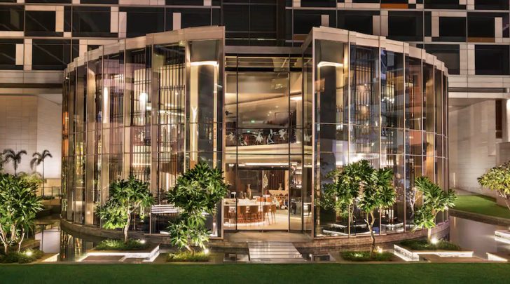 a building with glass walls and trees