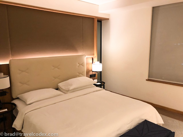 a bed with a lamp next to it
