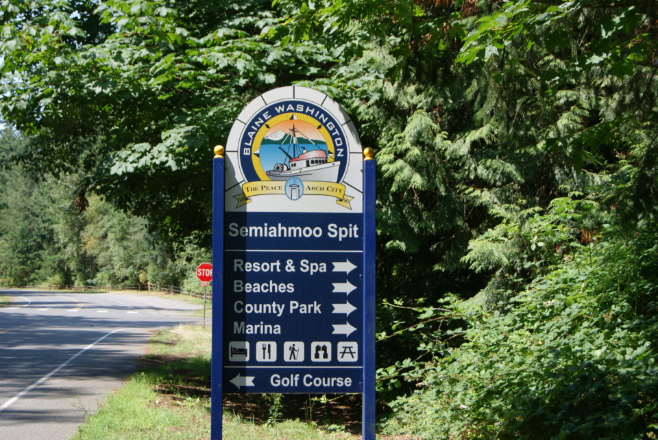 a sign with a road and trees