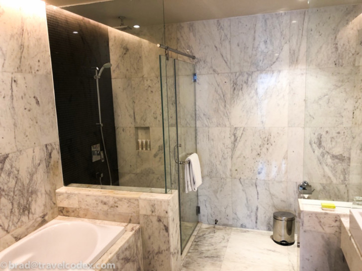 a bathroom with a glass shower and tub