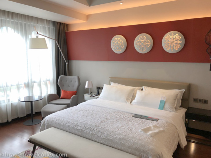 a bed with white pillows and a lamp in a room