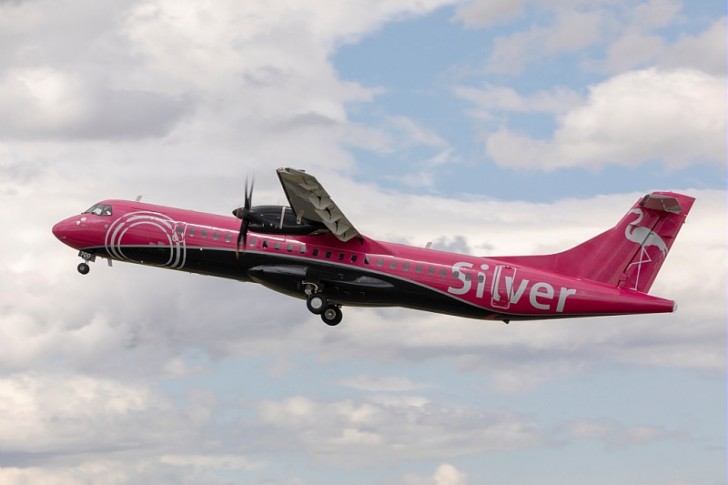 a pink airplane flying in the sky
