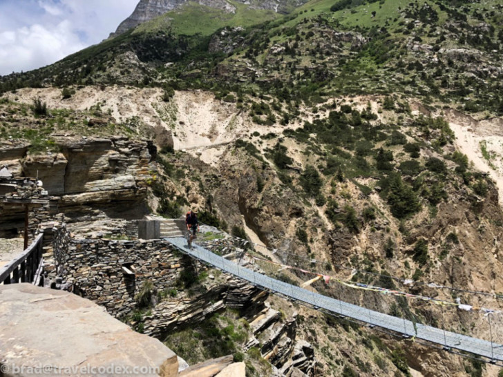 a person walking on a bridge over a canyon