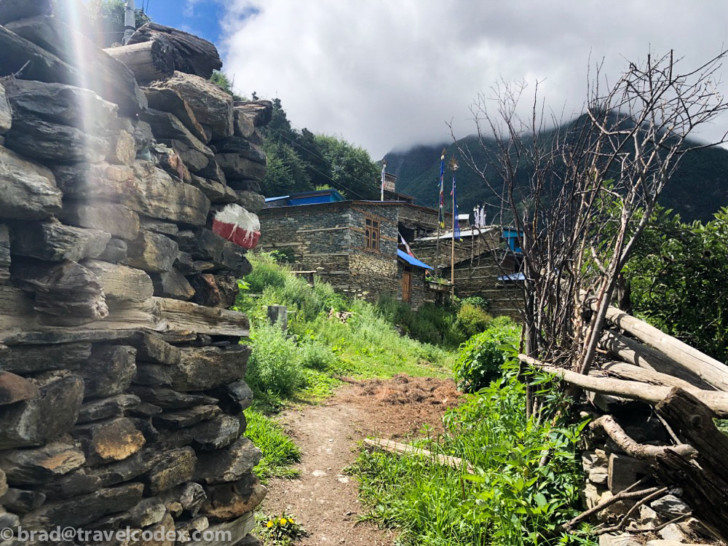 a stone wall with a building in the background