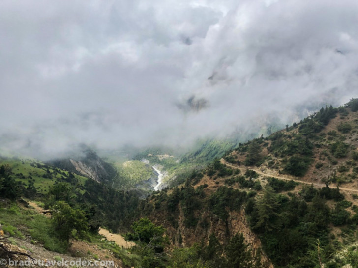a mountain with a road and clouds