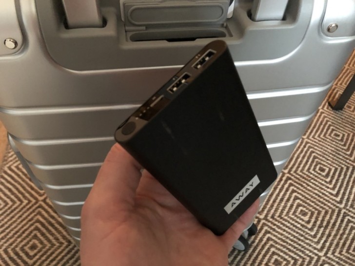 a hand holding a black device