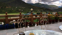 a table with wine on it and a view of mountains and a valley