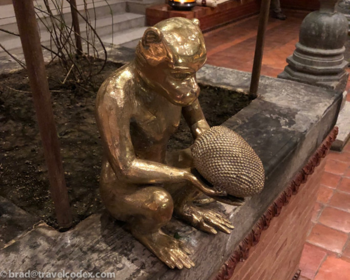 a statue of a monkey holding a fruit