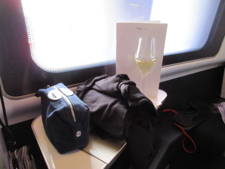 a bag and a glass of wine on a table