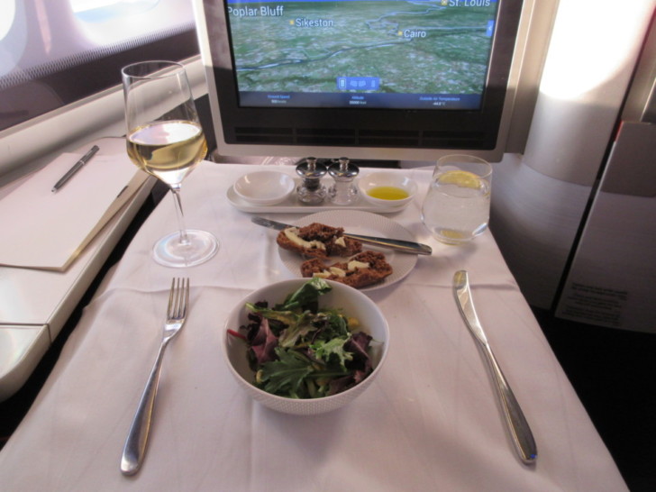 a table with a tv and a bowl of salad