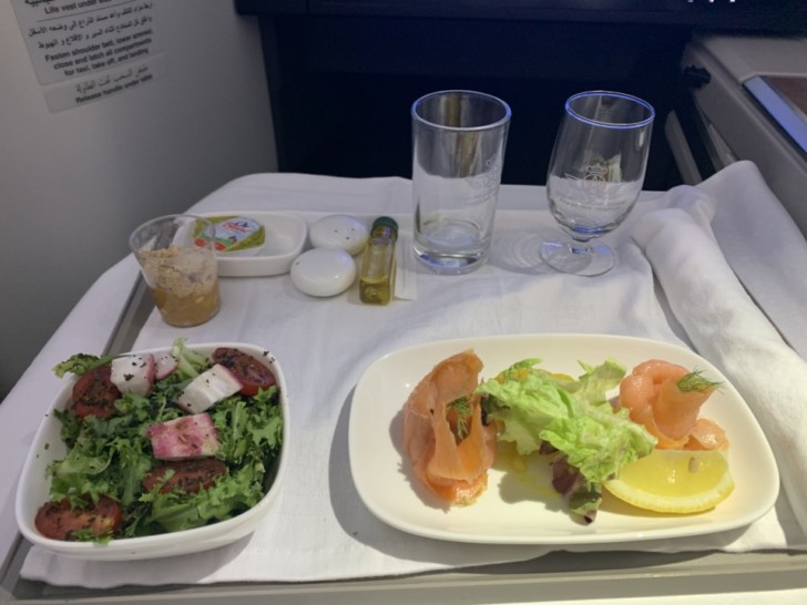 a plate of salad and a plate of food on a table