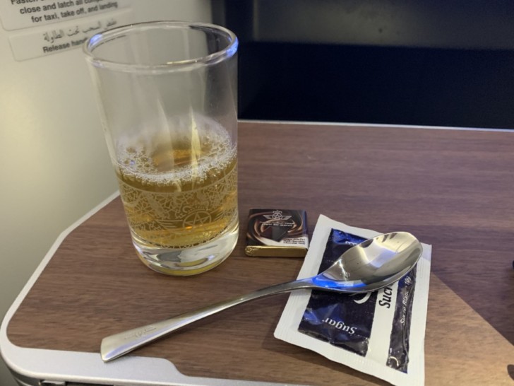 a glass of beer and a spoon on a table