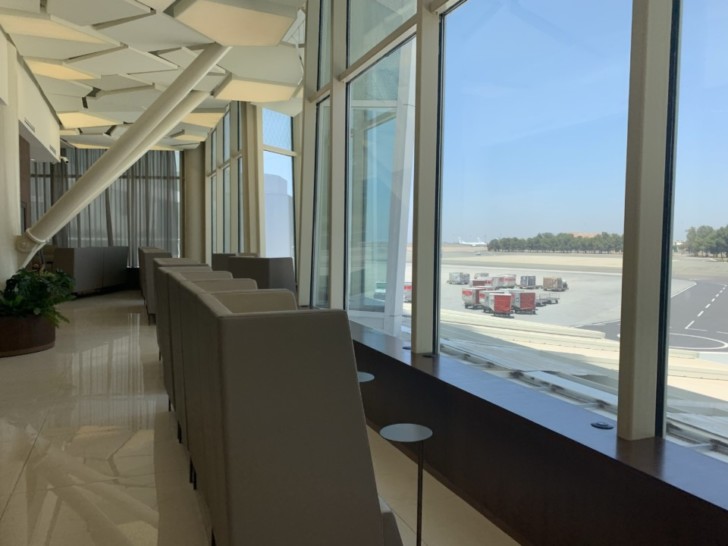 a row of chairs in a room with large windows