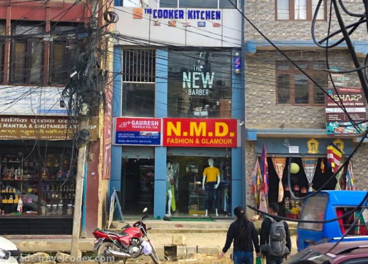a storefront with a sign and a motorcycle parked on the side of it