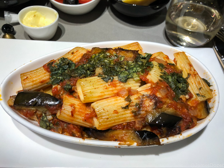 a plate of pasta with vegetables and sauce