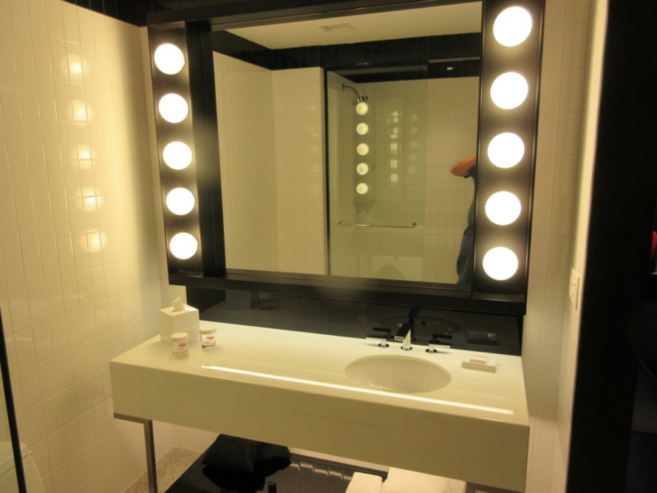 a bathroom with a large mirror and lights