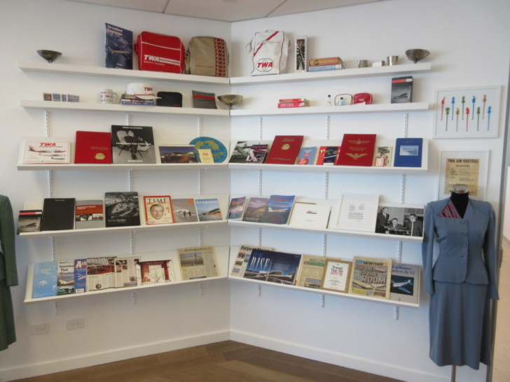 a woman standing in front of a wall with shelves of books