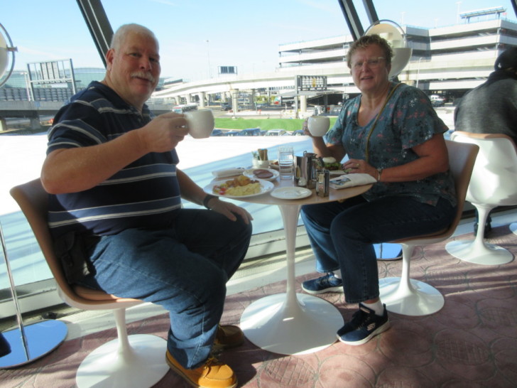 a man and woman sitting at a table with food