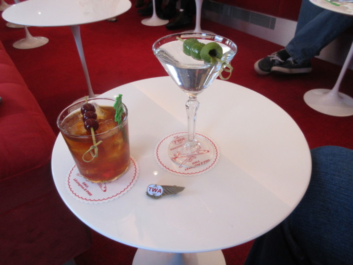 a glass of liquid and a drink on a white table