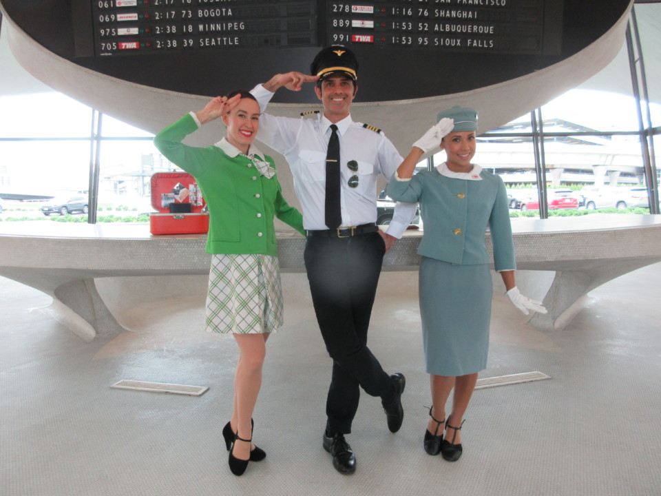 a man in uniform and stewardess saluting with other people