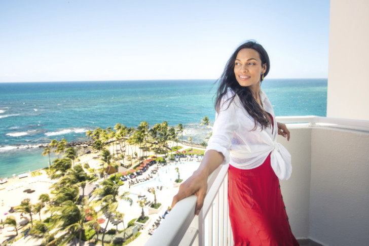 a woman leaning on a railing overlooking a body of water