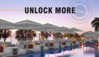 a pool with umbrellas and white furniture