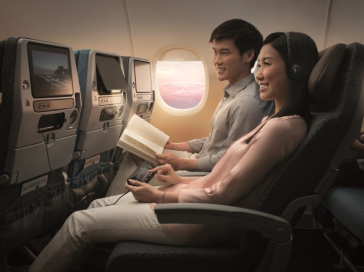 a man and woman sitting in an airplane