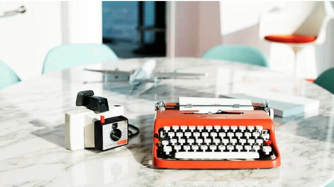 a typewriter and camera on a table