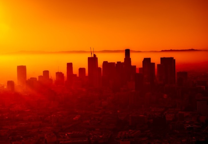 a city skyline with the sun setting behind it