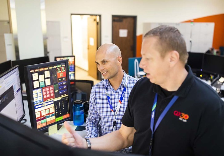 a group of men looking at a computer screen