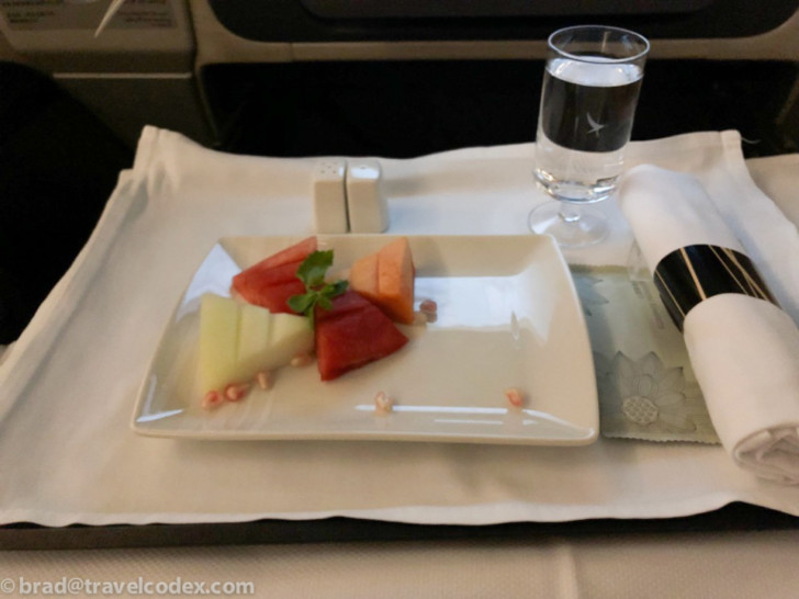 a plate of fruit and water on a tray