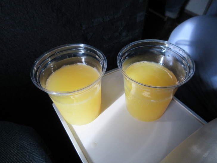 two plastic cups of orange juice