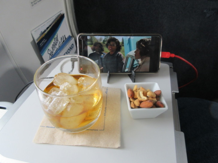 a glass of ice and a bowl of nuts on a table