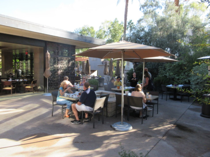 a group of people sitting at tables outside a building