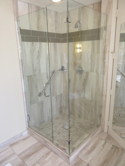 a glass shower with a handle