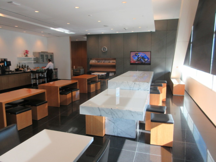 a room with a large white table and wooden benches