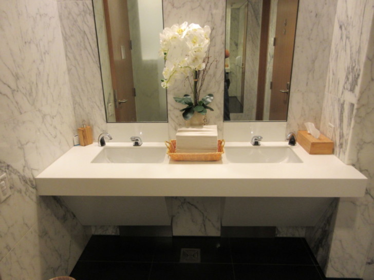 a bathroom with a white sink and two mirrors