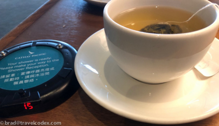 a cup of tea on a saucer next to a small round device