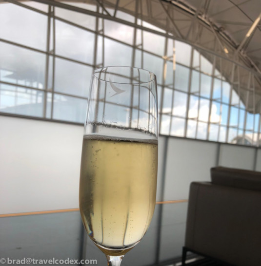 a glass of champagne in front of a large window