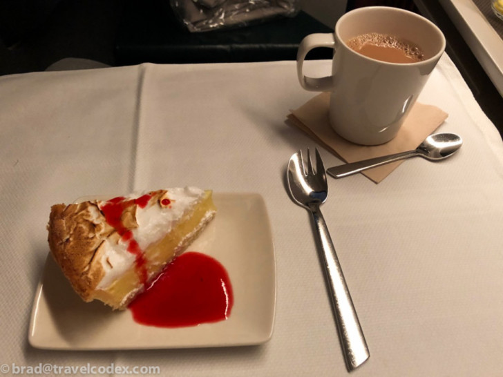a slice of pie with a drink in the background