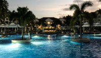 a pool with palm trees and buildings in the background