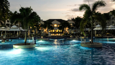 a pool with palm trees and buildings in the background
