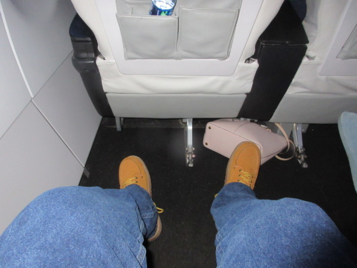 a person's legs and feet in a seat