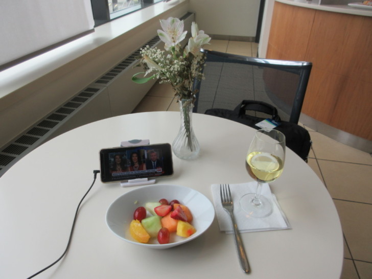 a bowl of fruit and a glass of wine on a table